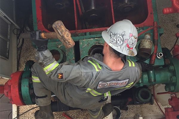 Labourer repairing oil equipment